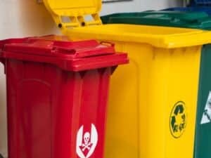 Bidoni colorati, il rosso con il simbolo dei rifiuti pericolosi suggerisce una separazione attenta per un'analisi dei rifiuti responsabile.