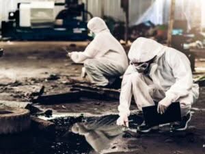 Specialisti in tute protettive eseguono la valutazione del rischio biologico in un ambiente di lavoro