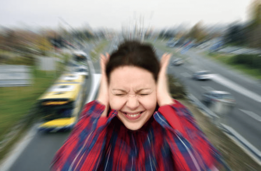 Donna si tappa le orecchie nel traffico stradale