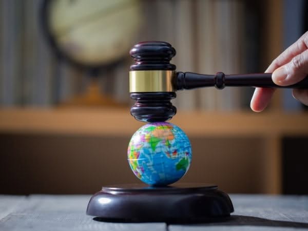 L'immagine raffigura un martelletto giudiziario che è in bilico su un piccolo mappamondo, simbolo della normativa ambiente.
