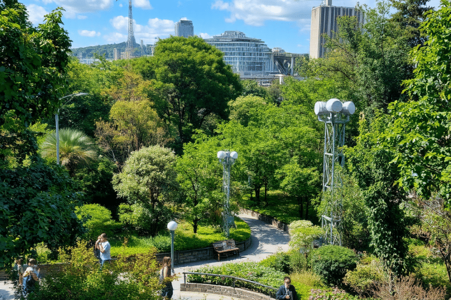 Un vibrante parco urbano con lussureggiante vegetazione, persone che si rilassano e una tecnologia discreta di monitoraggio della qualità dell'aria integrata nel paesaggio.